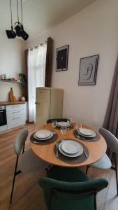 a dining room table with plates and wine glasses on it at Appartement au calme T3 RDC - Quartier de France in Vichy
