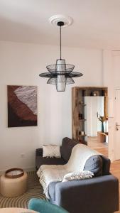 a living room with a couch and a chandelier at Appartement au calme T3 RDC - Quartier de France in Vichy