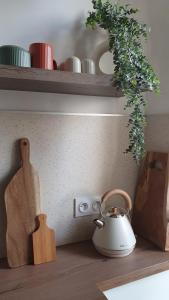 a shelf with a tea kettle on a wooden table at Appartement au calme T3 RDC - Quartier de France in Vichy