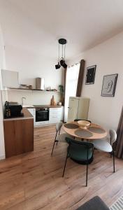 una cucina con un tavolo e sedie in una stanza di Appartement au calme T3 RDC - Quartier de France a Vichy
