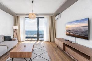 a living room with a couch and a tv at Vista Seaview in Sveti Stefan