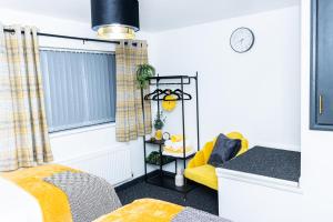 a room with a bed and a yellow chair at Wolverhampton 2 Bedroom House - PERFECT FOR CONTRACTORS-FAMILIES-LEISURES-LONG STAY! in Wolverhampton +23 photos