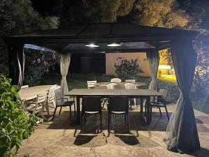 uma mesa e cadeiras debaixo de uma tenda preta em Meublé de tourisme MARTINET em Vénéjan
