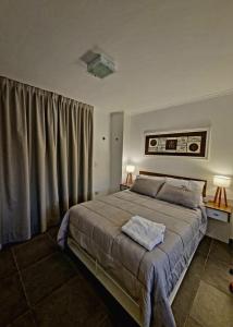 a bedroom with a large bed with two lamps and curtains at Monoambiente parque p in Villa María