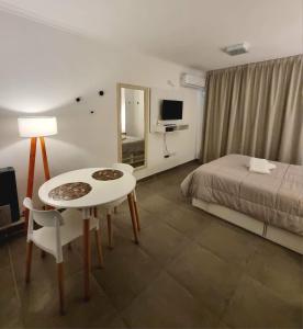 a hotel room with a bed and a table and a mirror at Monoambiente parque p in Villa María