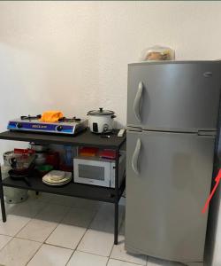 a kitchen with a refrigerator and a microwave on a cart at Casa Valeria in Puntarenas