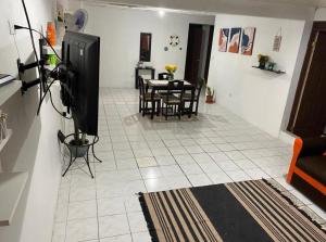 un soggiorno con TV, tavolo e sedie di Casa Valeria a Puntarenas