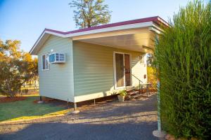 ein winziges Haus mit einer Veranda auf einem Hof in der Unterkunft Mitchell Motel & Cabin Park in Mitchell