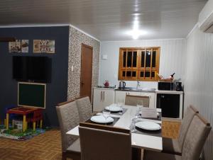 a kitchen with a table and chairs and a dining room at Gramado Família in Gramado