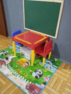uma mesa de brinquedo e um quadro negro no chão em Gramado Família em Gramado