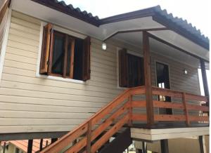 a house with a wooden deck with a porch at Gramado Família in Gramado