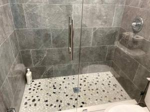 baño con ducha y puerta de cristal en Lovely 2-beds Central Clearwater Apartment en Clearwater