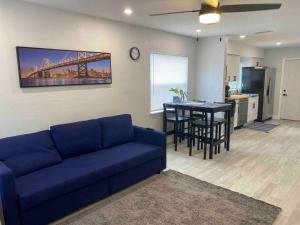 uma sala de estar com um sofá azul e uma cozinha em Lovely 2-beds Central Clearwater Apartment em Clearwater