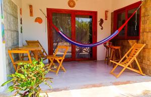 a patio with chairs and a hammock on a house at Flats Macapá Meu Amor in Luis Correia