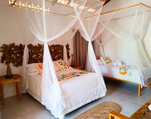 2 Betten in einem Zimmer mit Moskitonetzen in der Unterkunft Flats Macapá Meu Amor in Luis Correia