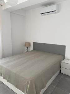 um quarto branco com uma cama e um candeeiro em Apartamentos La Gaviota em Roquetas de Mar
