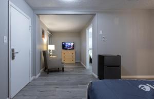 a bedroom with a bed and a desk and a television at Sunglow Motel in Bicknell