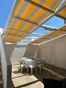 eine Terrasse mit einem Tisch und Stühlen auf dem Dach in der Unterkunft Perla Marina in Capitolo