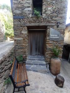 a wooden bench sitting in front of a building at Susurros del Manadero in Robledillo de Gata