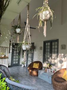 a room with chairs and potted plants hanging from the ceiling at The Bougainvillea Bed & Breakfast in Amritsar