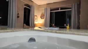 bañera en una habitación con 2 ventanas en Casa Grega, en Governador Celso Ramos