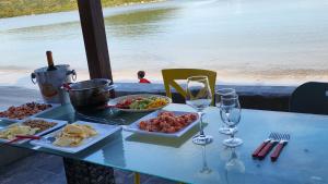 a table with plates of food and glasses of wine at Casa Grega in Governador Celso Ramos