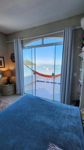 1 dormitorio con 1 cama y vistas al océano en Casa Grega, en Governador Celso Ramos