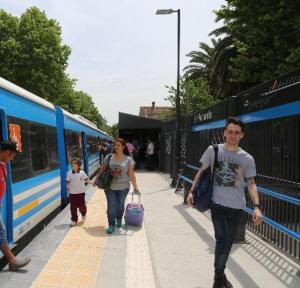 a man and woman and a child walking next to a train at Luminoso Depto S Fernando a 100 m Estación in San Fernando