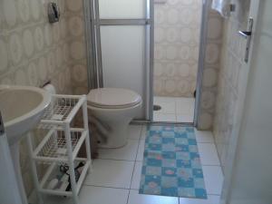 a bathroom with a toilet and a sink and a shower at Apartamento Aconchegante in São Vicente