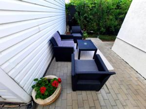 un patio con 4 sillas, una mesa y flores en Bucharest Wheel View, en Bucarest
