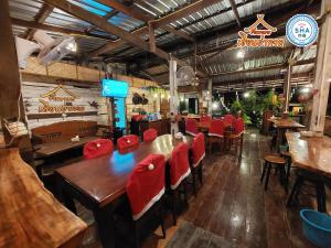 a restaurant with wooden tables and red chairs at Rapeepat Residential and Resort in Ban Nong Khaman