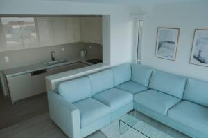 ein Wohnzimmer mit einem blauen Sofa und einer Küche in der Unterkunft Nicol's view in Prasás