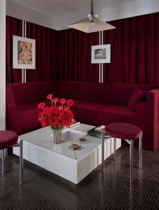パリにあるPied A Terre - Arts et Métiersのリビングルーム(赤いソファ、花のテーブル付)