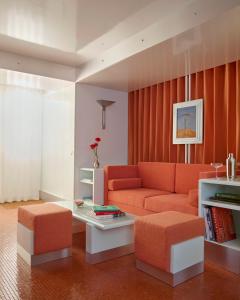 Una sala de estar con un sofá naranja y una mesa. en Pied A Terre Arts et Métiers, en París 24 fotos más
