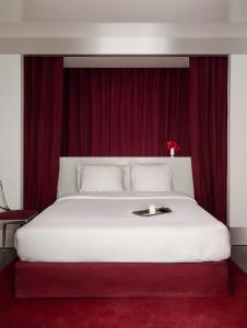 パリにあるPied A Terre - Arts et Métiersのベッドルーム(赤いカーテン付きの白い大型ベッド1台付)