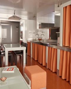 パリにあるPied A Terre - Arts et Métiersのキッチン(オレンジ色のカーテン、白いテーブル付)