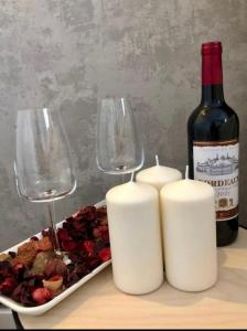 butelkę wina, dwa kieliszki i talerz jedzenia. w obiekcie AirPort Apartment w Warszawie