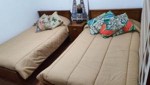 Hostal Costa Brava في إكيكي: سريرين يجلسون بجانب بعض في غرفة