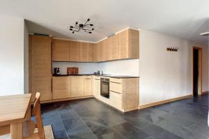 una cocina con armarios de madera y una mesa en una habitación en Ambassador 103, en Verbier
