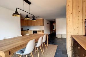 Il comprend une cuisine et une salle à manger avec une table et des chaises en bois. dans l'établissement Ambassador 103, à Verbier