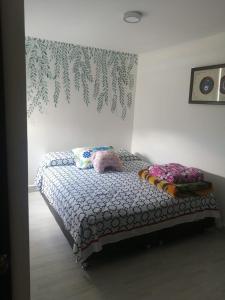 a bed with pillows on it in a bedroom at Apto Sabaneta 2 habitaciones al lado Centro Comercial Mayorca in Sabaneta