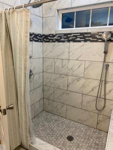 a bathroom with a shower with marble tiles at La Casa Grande Hosting in Whitsett