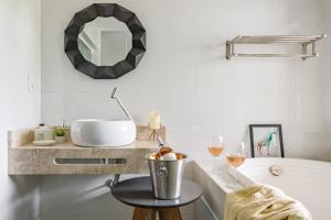 uma casa de banho com um lavatório e um espelho em Pinheira Beach House com Jacuzzi em Palhoça