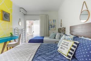 Pinheira Beach House com Jacuzzi في باليوسا: غرفة نوم بسريرين مع وسائد زرقاء وبيضاء
