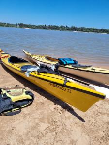 dos kayaks están sentados en la playa junto al agua en Nuevo, Bellísimo, Confort y muy amplio - 2 Dormitorios, uno en Suite - 2 baños y Pileta !! en Rosario