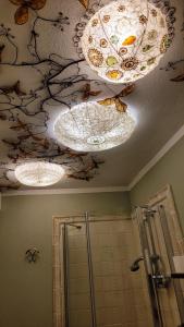 baño con 3 lámparas de araña y techo con mariposas en DeTillierStudiò en Aosta