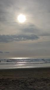 una persona caminando por la playa cerca del océano en Estancias De Olon en Olón