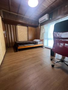een slaapkamer met een bed en een stoel in een kamer bij ※Japanese Only【villa Ukishima】 in Naha