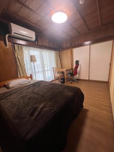 a bedroom with a bed and a desk and a table at ※Japanese Only【villa Ukishima】 in Naha