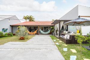 ein Haus mit einer Hängematte draußen in der Unterkunft Pinheira Beach House com Jacuzzi in Palhoça